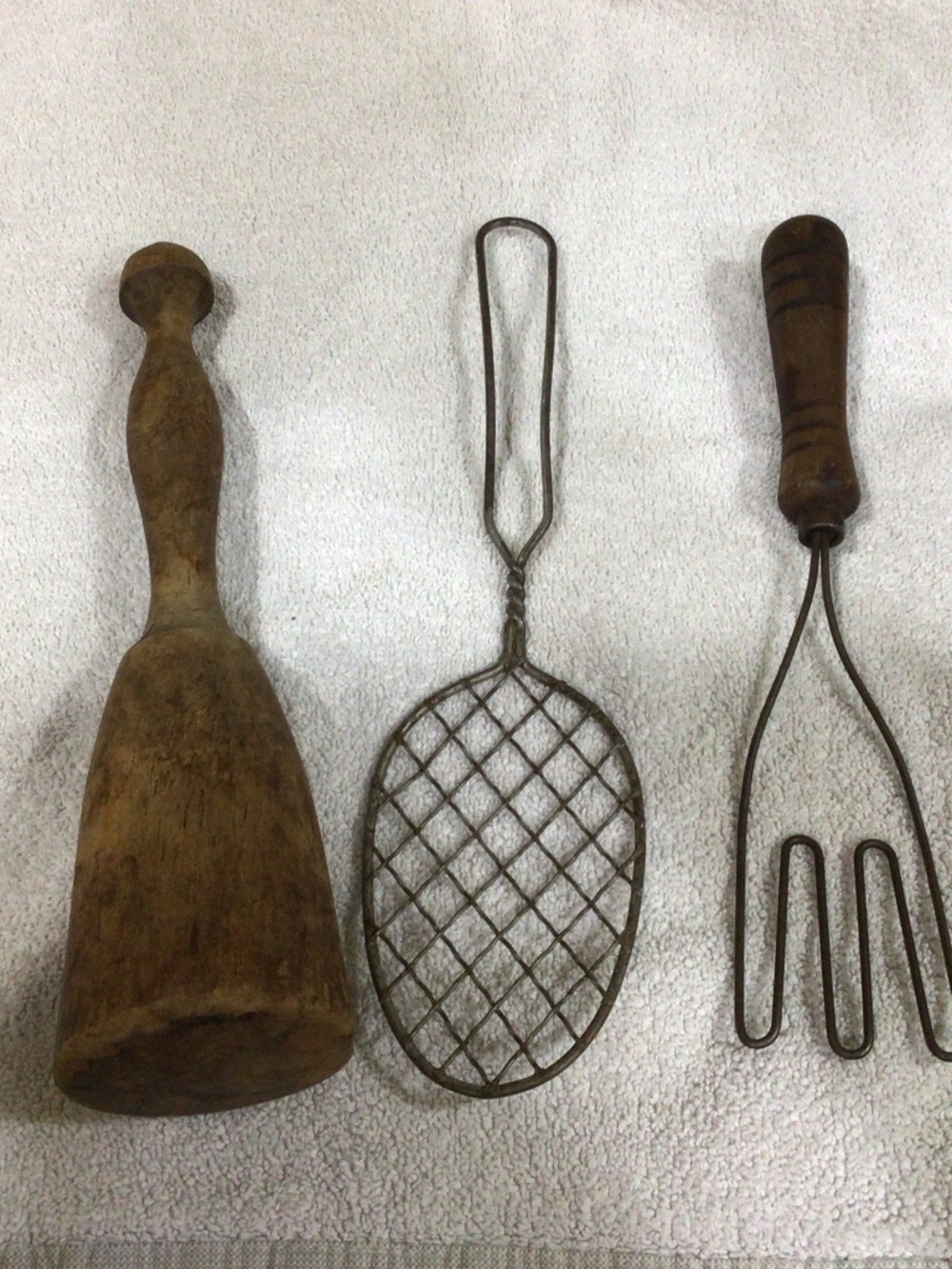 Primitive kitchen set for display. Wooden pestle, potato masher and skimmer.